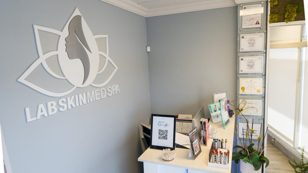 Lab Skin Med Spa reception with the illuminated lotus logo
